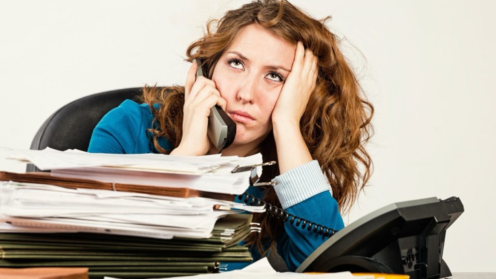 Donna stufa di essere sommersa da carte e oberata di lavoro